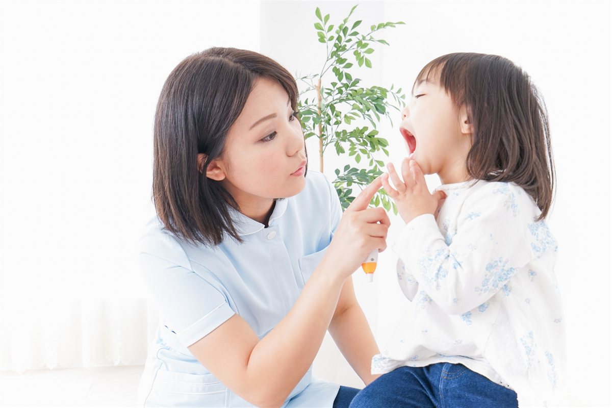 スタッフがお子さまのお口を確認する様子